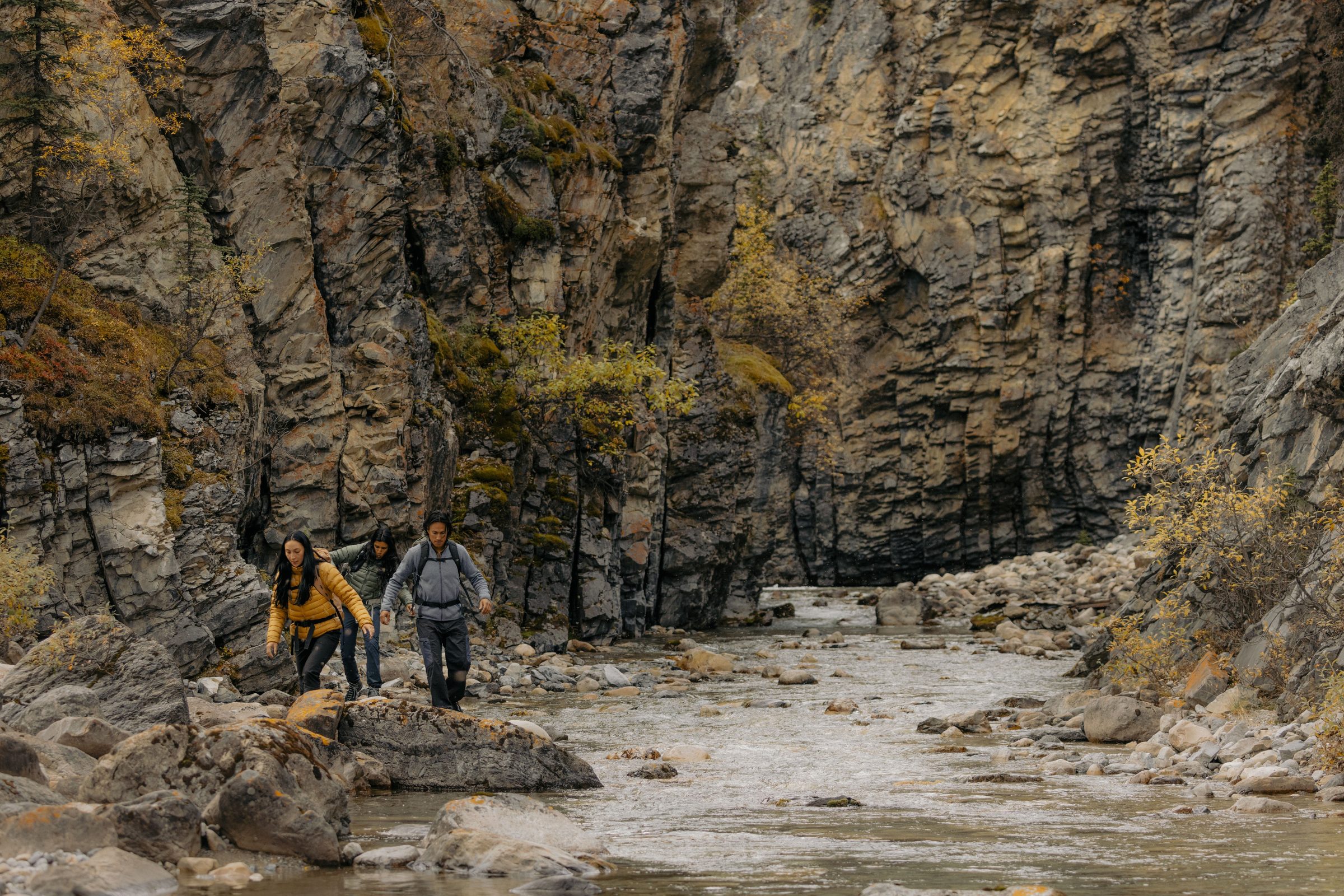 Hikers navigating a canyon riverbed in Northeast BC